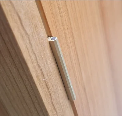 Nahtlos eingelassenes Messingscharnier in der Tür eines handgefertigten Highboards