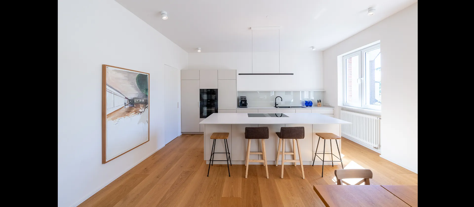 Moderne Einbauküche mit freistehendem Kochblock und weißen Fronten, gefertigt von MTB Schreinerei in Mannheim – Heidelberg – Weinheim.