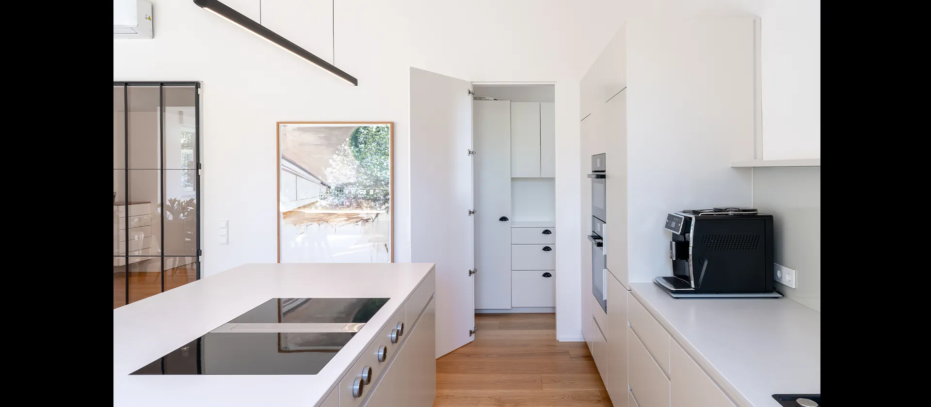 Offene Küche mit Kochinsel und Durchgang zur maßgefertigten Speisekammer, präzise umgesetzt von der MTB Schreinerei.