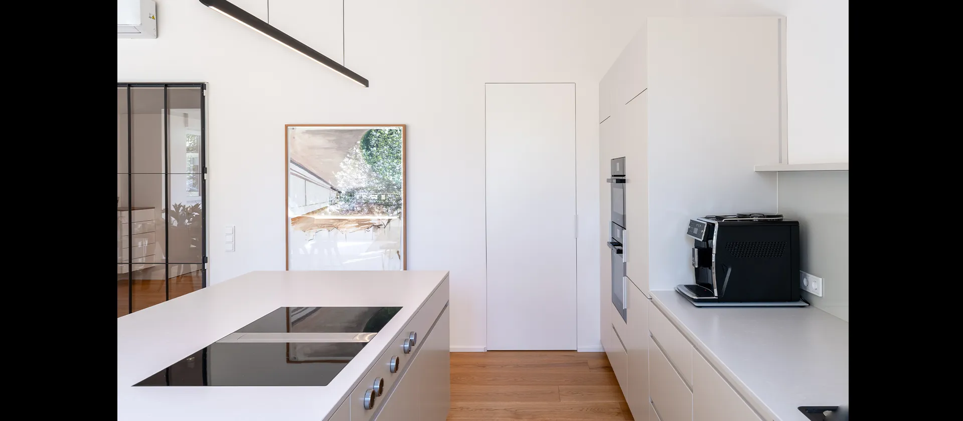 Küchenwand mit integrierter Tür zur Speisekammer, klare Linienführung und harmonische Flächenoptik in handwerklicher Maßarbeit.