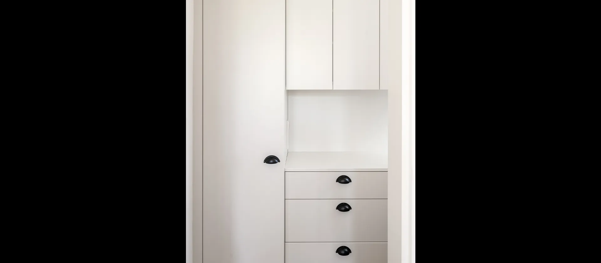 Maßgefertigte Einbauten in der Speisekammer mit schlichten Fronten und kontrastierenden Griffen – hochwertige Schreinerarbeit von MTB.